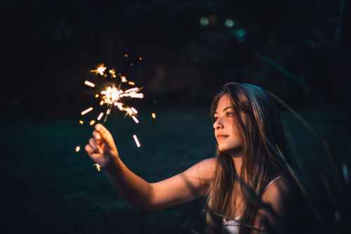 photo of woman holding sparkler
