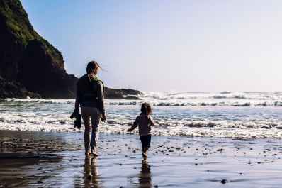 girl and toddler walking at the shore